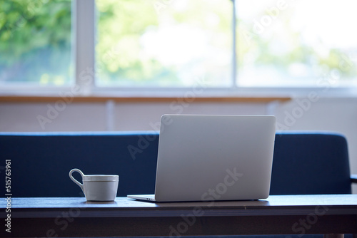 リビングの机に置かれたマグカップとノートパソコン