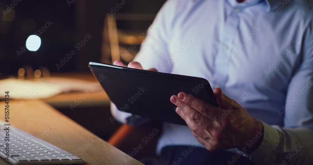 Closeup of a business man working late on a digital tablet in an office. Hands of a dedicated and organized manager searching the internet, scrolling online, browsing apps and planning ideas at night