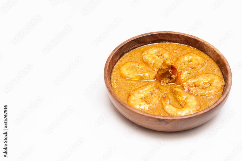 Bengali Dish or Food - Delicious authentic Bengali Prawn Malai Curry also known as chingri malai curry served on a wooden bowl. Traditional Goan Prawns or Shrimp curry. top view white background. Bengali Dish or Food - Delicious authentic Bengali Prawn Malai Curry also known as chingri malai curry served on a wooden bowl. Traditional Goan Prawns or Shrimp curry. top view white background.