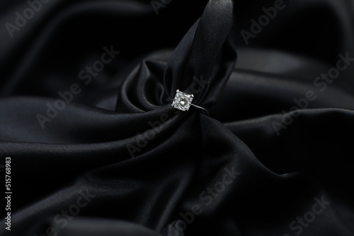 Fine jewelry as diamond ring with diamond with black satin fabric background. Jewelry shop concept