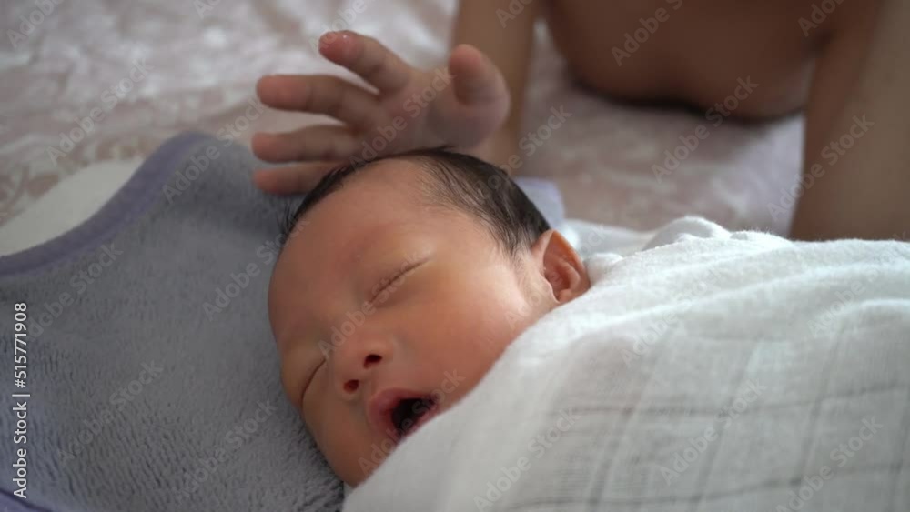 Newborn baby smile when his brother touch his head Newborn baby smile when his brother touch his head