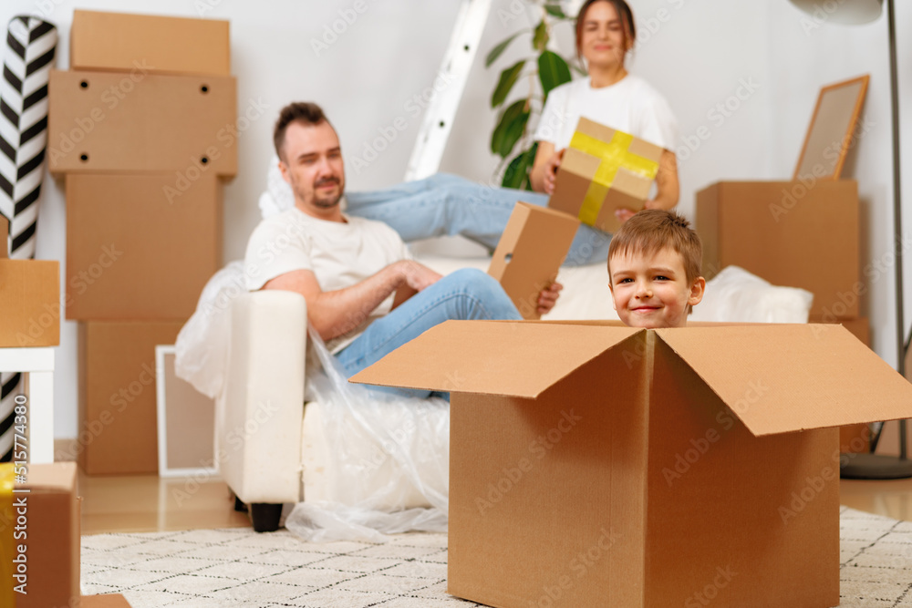 Parents and son packing boxes and moving into a new home Parents and son packing boxes and moving into a new home