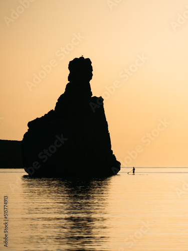 Silhouette of a man floating on a supboard at sunset in Ibiza photo