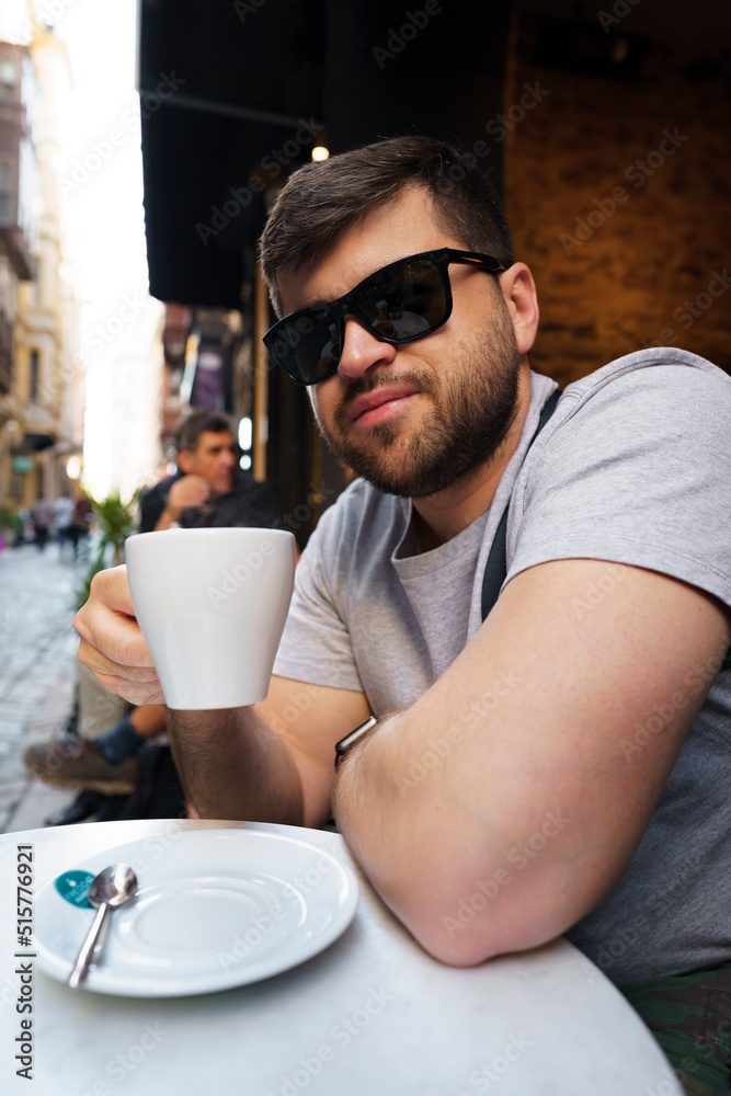 Handsome man drinking coffee in outdoor cafe Handsome man drinking coffee in outdoor cafe