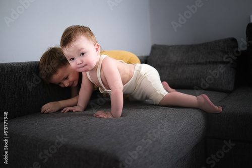 Sibling children play on sofa in living room together