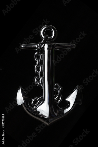 Shiny anchor with chain on black background..