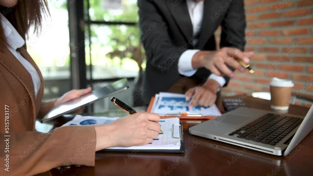 Business documents on office table with smart phone and calculator digital tablet and graph business with social network diagram and two colleagues discussing data working Business documents on office table with smart phone and calculator digital tablet and graph business with social network diagram and two colleagues discussing data working