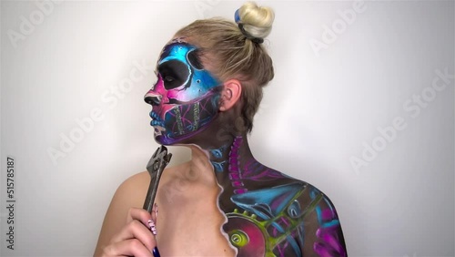 Portrait of young woman with scared halloween makeup holding a spanner photo