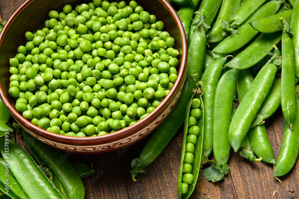 green sweet peas on a dark wooden background, still life, concept of fresh and healthy food green sweet peas on a dark wooden background, still life, concept of fresh and healthy food