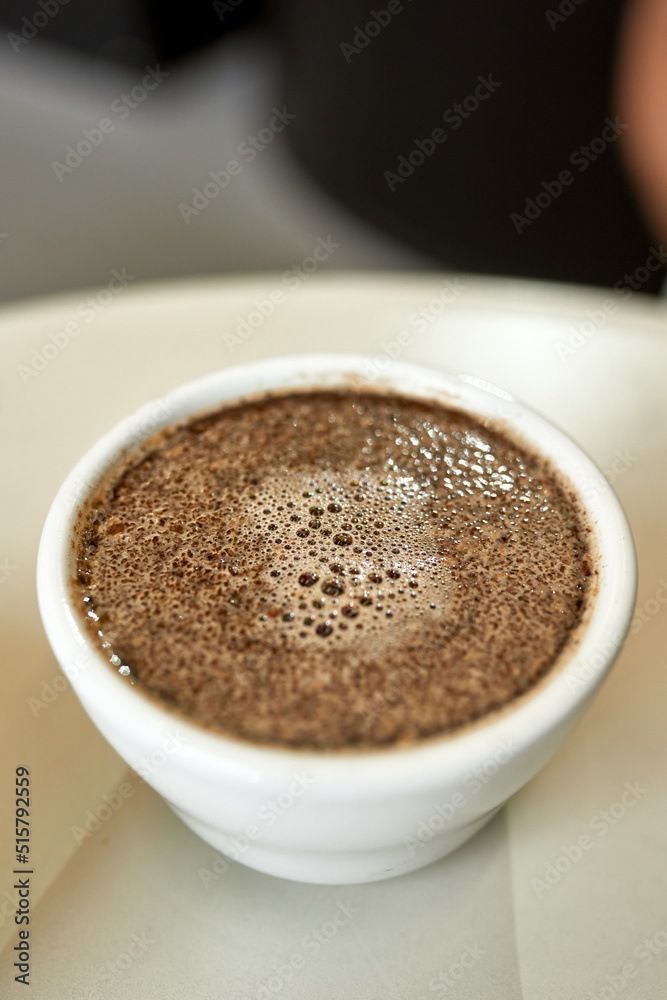 Close up of cup with brewed coffee on plate Close up of cup with brewed coffee on plate