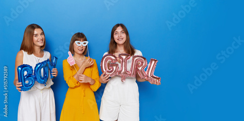 A group of happy women to have gender reveals envent, isolated blue background. Space for text. photo