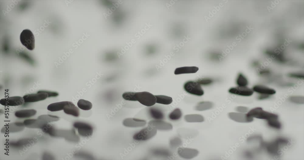 Black sesame falls on a light mirror surface Black sesame falls on a light mirror surface
