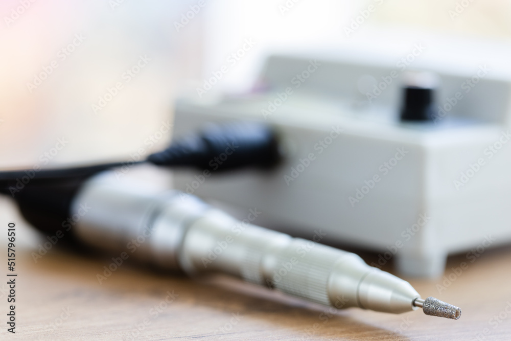 Naklejka premium Manicure machine closeup. Metallic fraser on the desk. Selective focus.