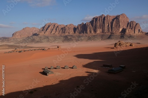 Amazing scenery of Wadi Rum desert. Bedouin tents in valley. Jabal Al Qatar mountain on horizon.