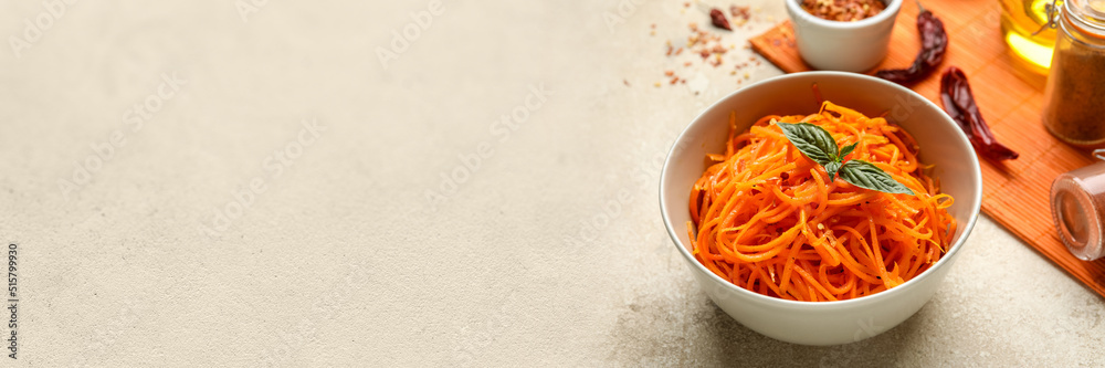 Bowl with spicy Korean carrot salad on grey background with space for text Bowl with spicy Korean carrot salad on grey background with space for text