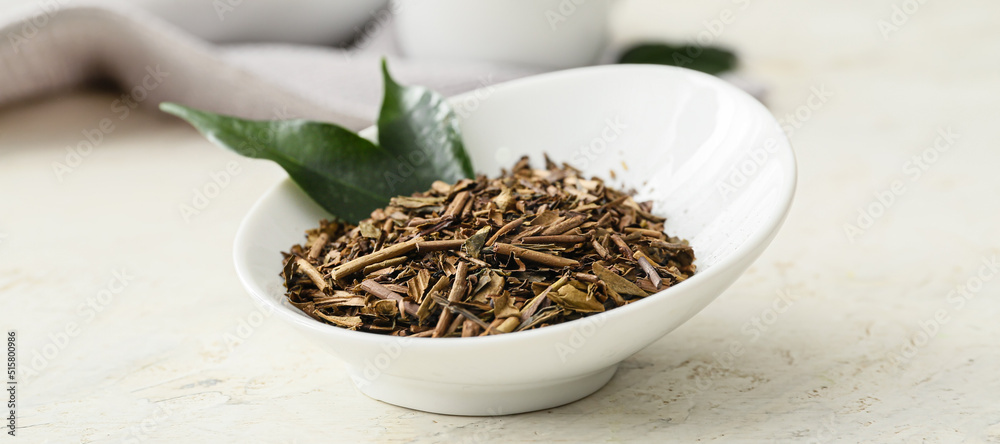 Fototapeta premium Bowl of dry hojicha green tea on light background