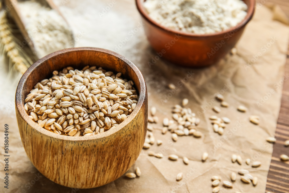 Bowl with wheat grains on parchment paper, closeup Bowl with wheat grains on parchment paper, closeup