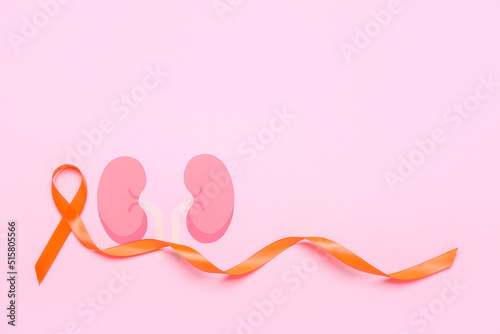 Orange awareness ribbon and paper kidneys on pink background