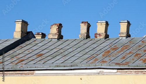 Old brick pipes on the roof of the house.