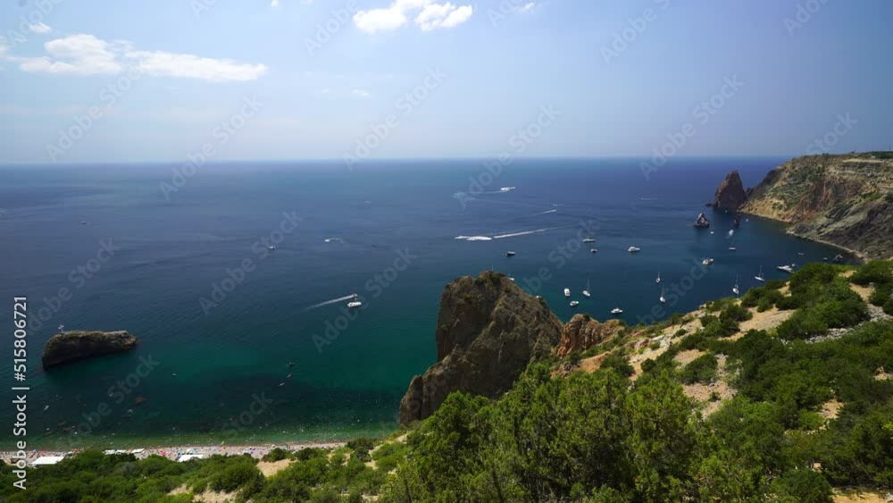 Aerial panoramic view of seascape with crystal clear azure sea and rocky shores. Yachts in a beautiful lagoon on backdrop of rocks. The concept of an ideal destination for summer travel and vacation. Aerial panoramic view of seascape with crystal clear azure sea and rocky shores. Yachts in a beautiful lagoon on backdrop of rocks. The concept of an ideal destination for summer travel and vacation.