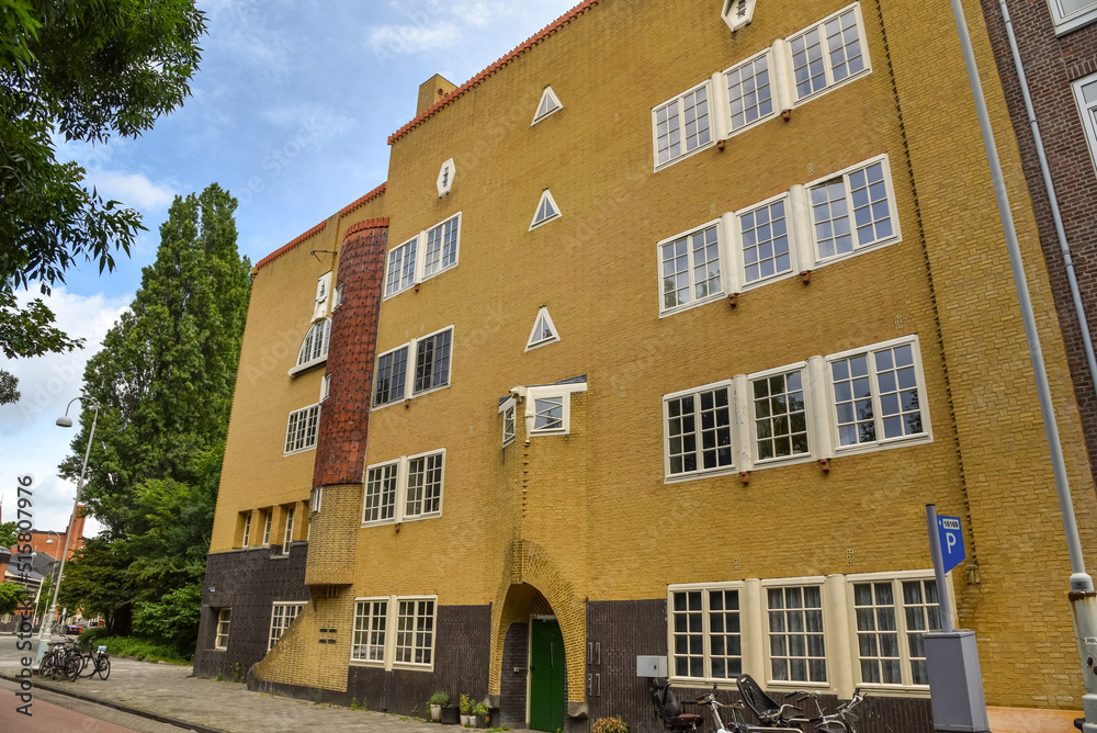 Amsterdam, Netherlands. June 2022. View of characteristic brick residential building in the style of the Amsterdam School in Spaarndammerbuurt, Amsterdam. Amsterdam, Netherlands. June 2022. View of characteristic brick residential building in the style of the Amsterdam School in Spaarndammerbuurt, Amsterdam.