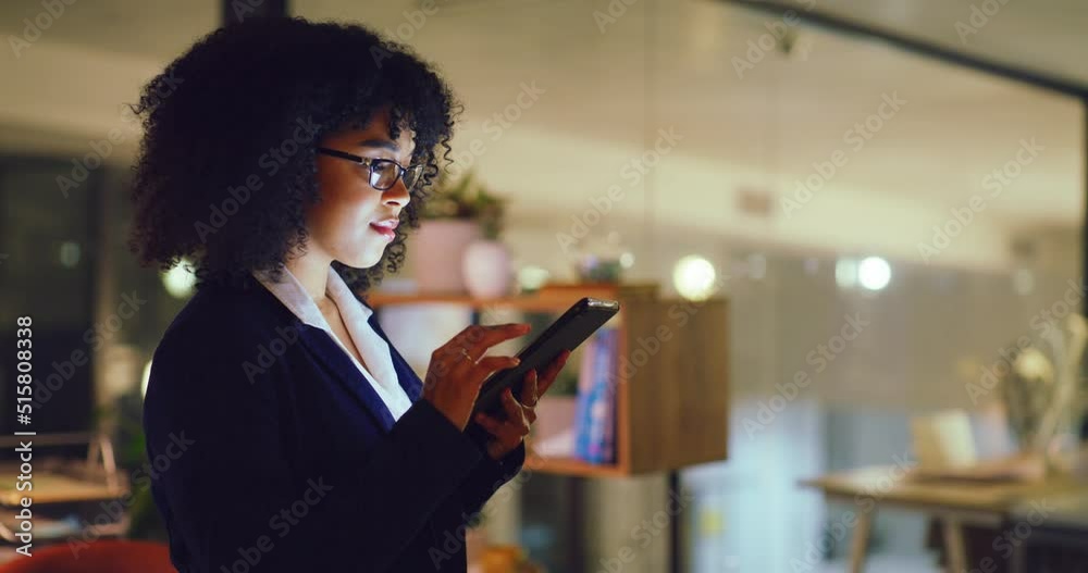 Young business woman at night using a digital tablet in an office. Dedicated and organized corporate executive searching the internet, scrolling online, browsing apps and planning ideas for deadlines
