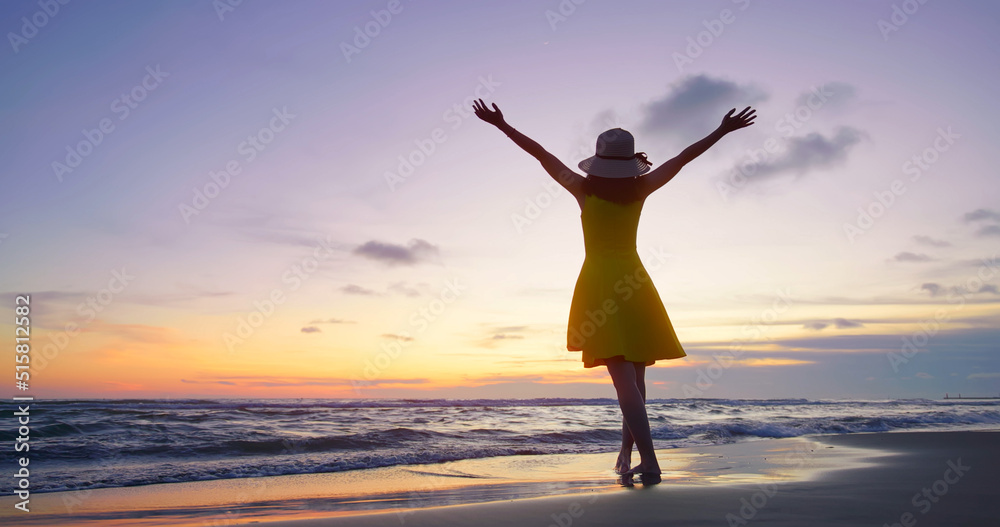 girl raise hands at beach