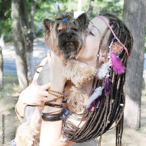 Happy smiling young woman kissing her yorkshire terrier dog