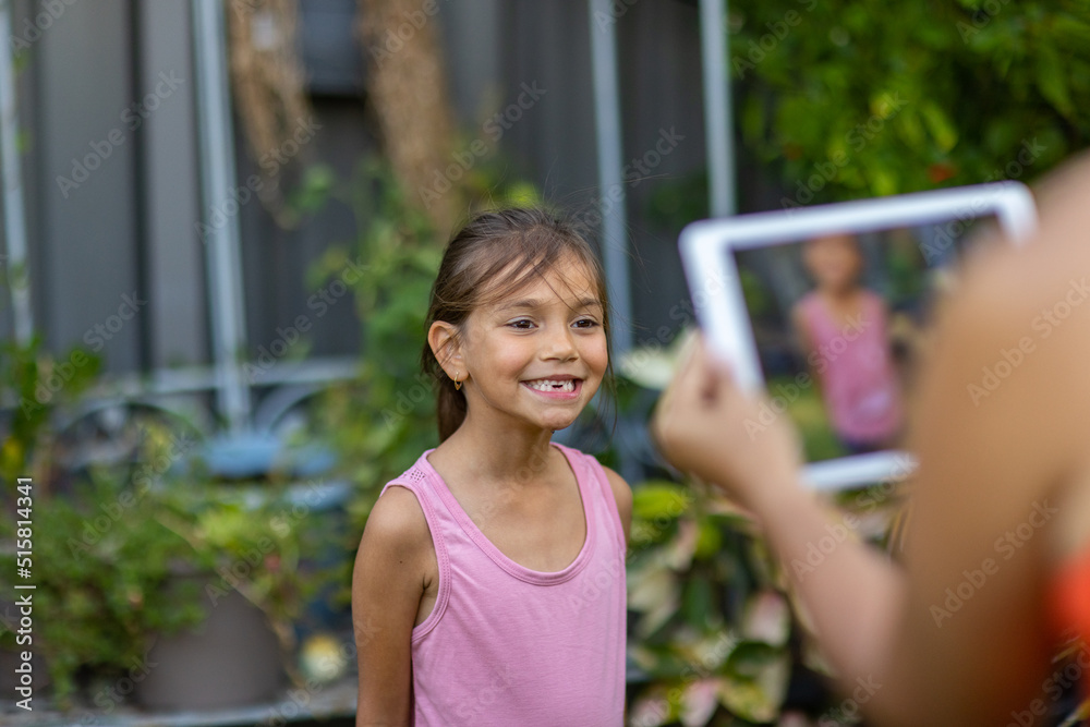 custom made wallpaper toronto digitallittle girl smiling while her mother takes a photo of her on digital tablet