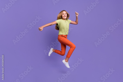 Full length photo of excited sporty person jump run rush fast isolated on violet color background © deagreez