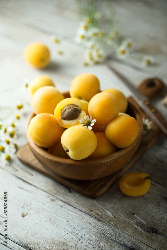 Fresh ripe apricots in a wooden bowl Fresh ripe apricots in a wooden bowl
