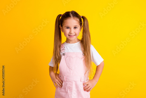 Photo of cute charming school girl wear summer outfit smiling hands arms waist isolated yellow color background