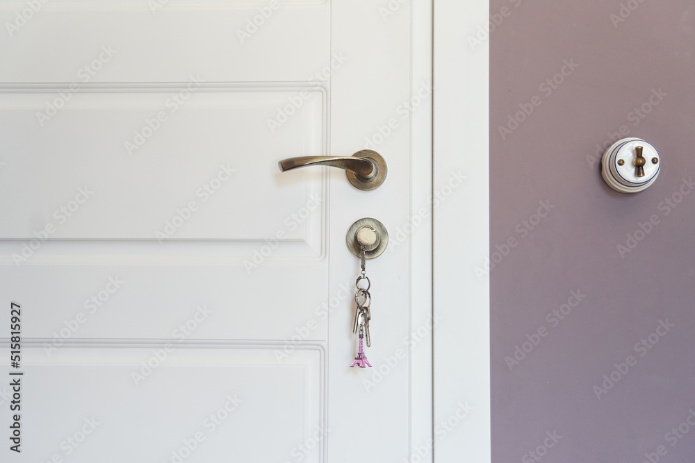 Part of white modern interior door with key in lock and metal handle. High quality photo Part of white modern interior door with key in lock and metal handle. High quality photo