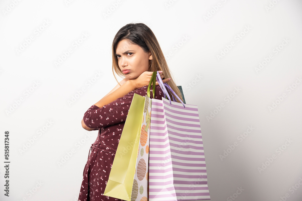 Young woman holding shop bags on white background Young woman holding shop bags on white background