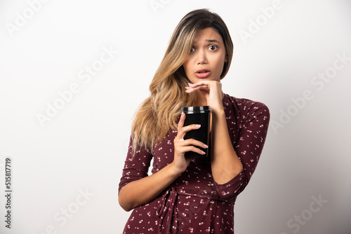 Young woman showing a cup of drink on white background
