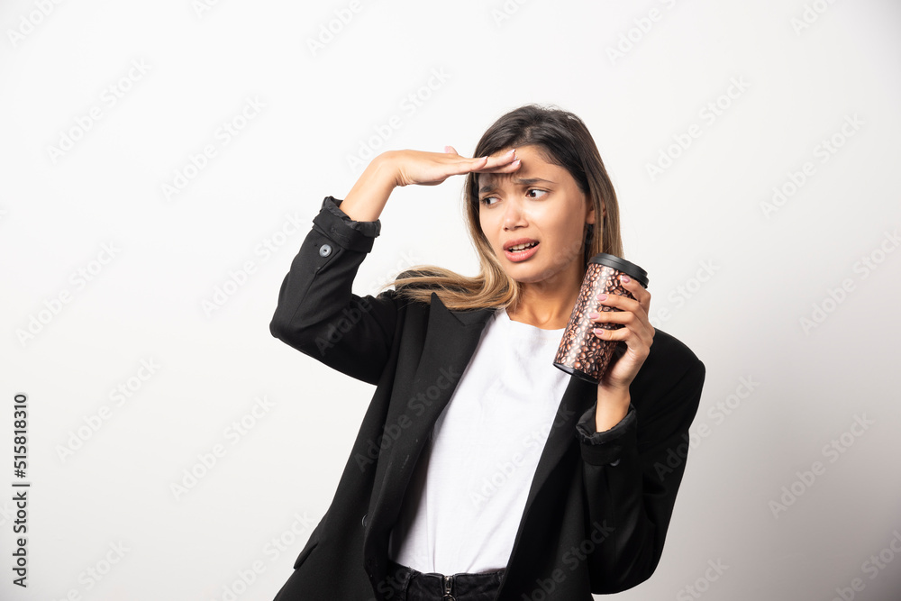 Business woman holding cup and posing on white background Business woman holding cup and posing on white background