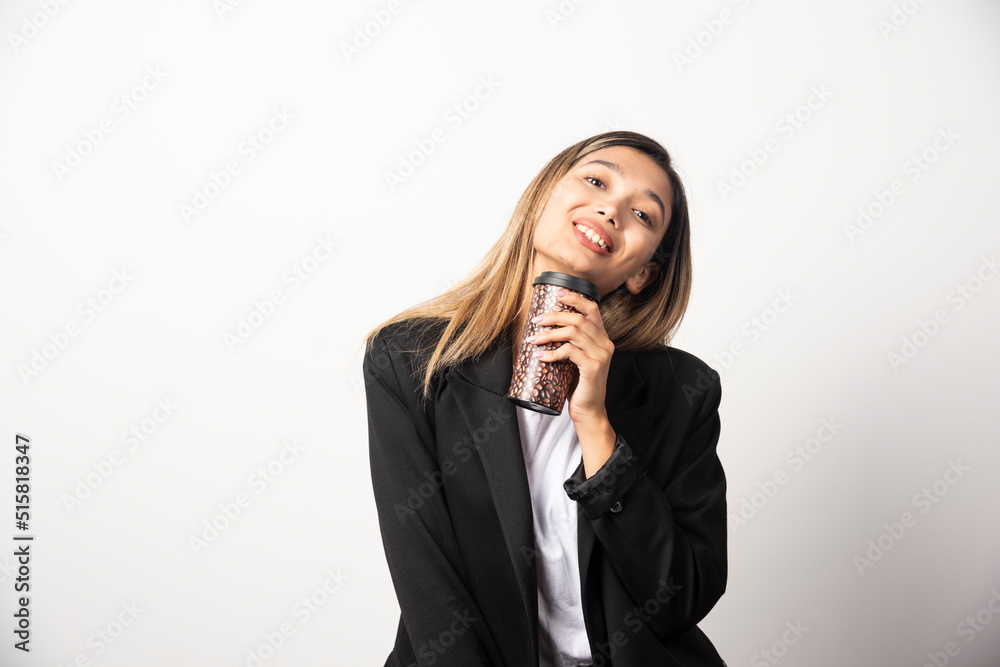 Business woman holding cup and posing on white background Business woman holding cup and posing on white background