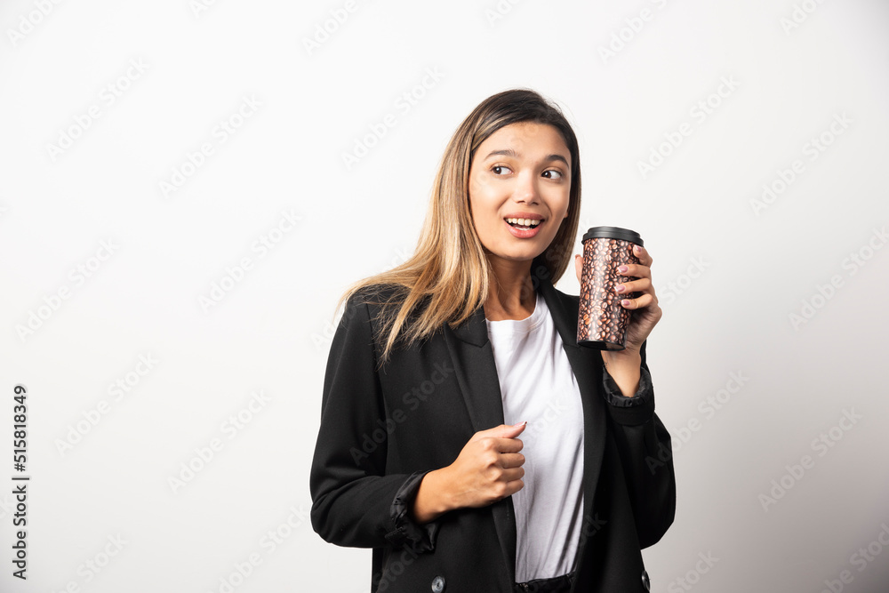 Business woman holding cup and posing on white background Business woman holding cup and posing on white background