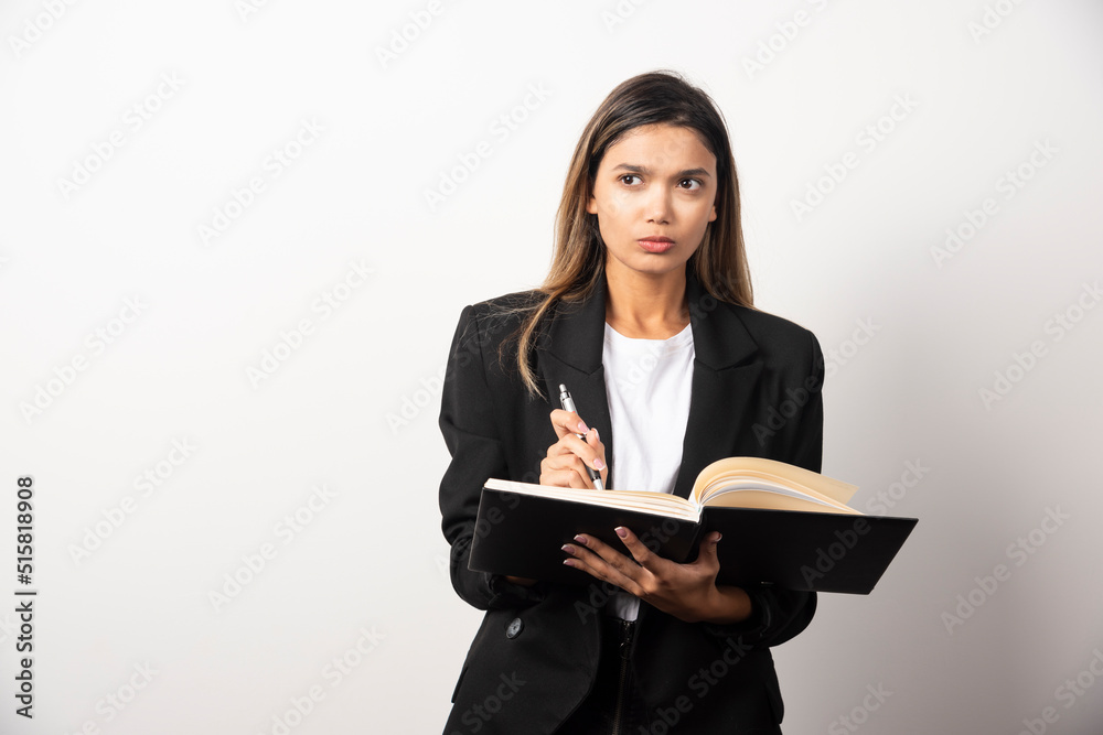 Young businesswoman holding an opened clipboard with pencil Young businesswoman holding an opened clipboard with pencil
