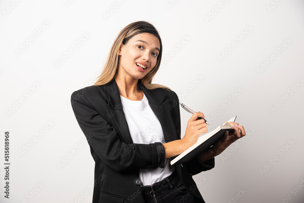 Young businesswoman writing in clipboard with pencil Young businesswoman writing in clipboard with pencil