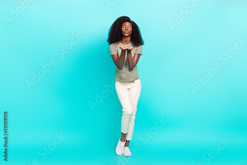 Full size portrait of lovely cute girl closed eyes arms palms send you air kiss isolated on emerald color background