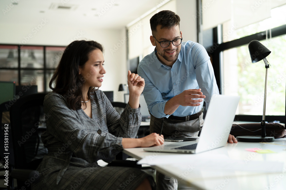 © JustLife - Colleagues in office. Businesswoman and businessman discussing work in office
