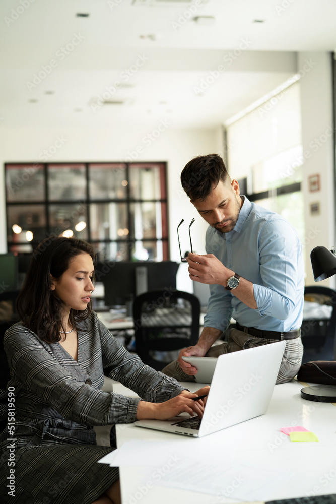 Colleagues in office. Businesswoman and businessman discussing work in office Colleagues in office. Businesswoman and businessman discussing work in office