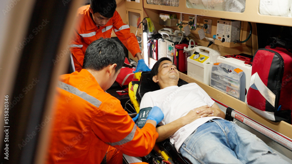 Emergency medical technician (EMT) or paramedic using blood pressure set with patient in ambulance car Emergency medical technician (EMT) or paramedic using blood pressure set with patient in ambulance car