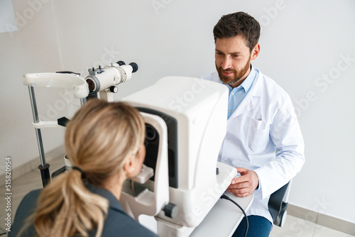 Male ophthalmologist checks a patient s vision at an opticians shop or ophthalmology clinic