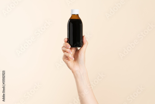 Image of hand holding a cold liquid medicine.