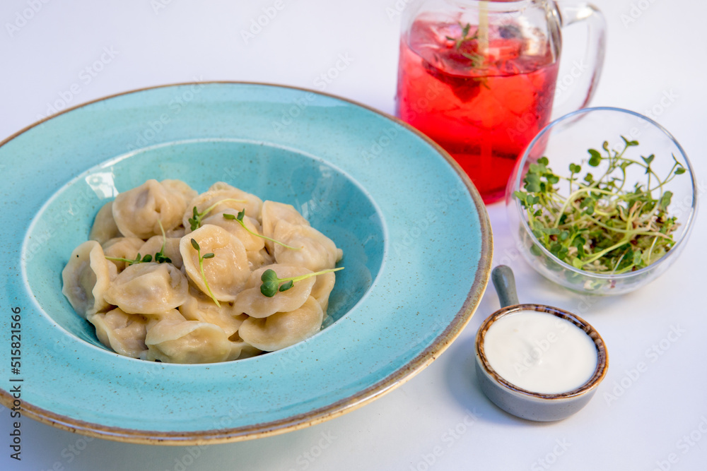 Dumplings with meat, sour cream, microgreens