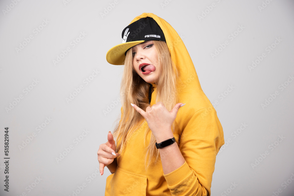 Portrait of woman in hoodie showing telephone sign Portrait of woman in hoodie showing telephone sign