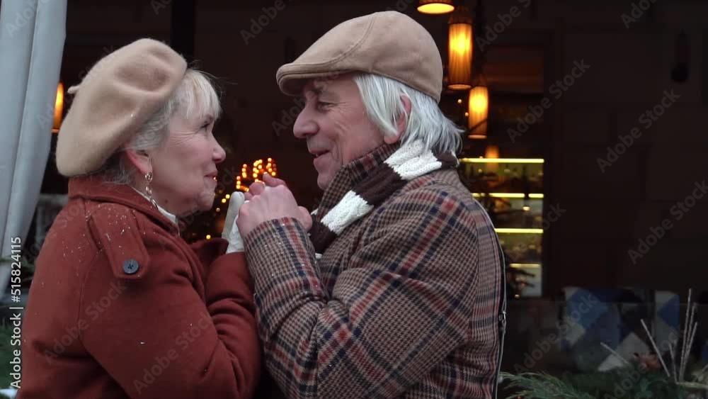 Elderly caring man warms wife's hands with breath. Valentine's day Elderly caring man warms wife's hands with breath. Valentine's day