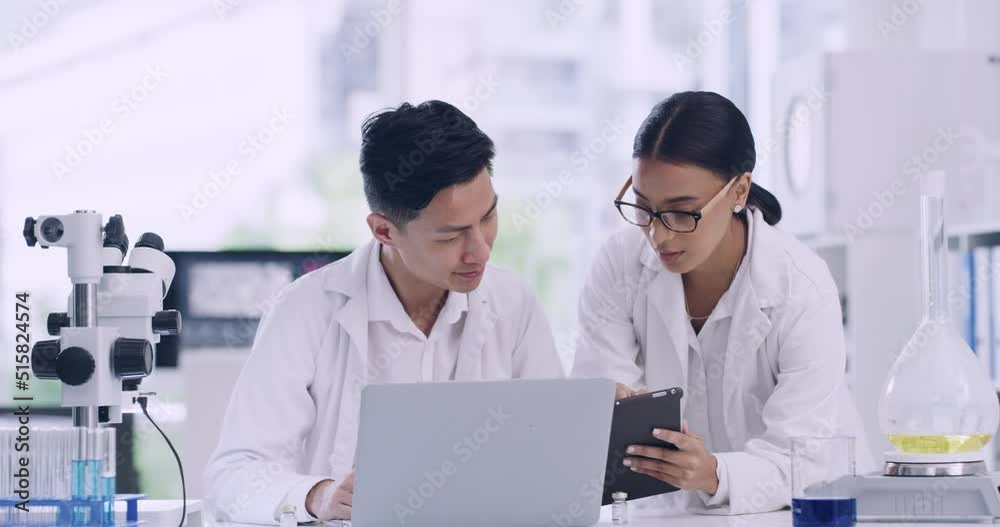 Colleagues discussing forensic research and findings while analyzing medical data. Microbiologists developing innovative ideas with biotechnology. Two scientists working on a digital tablet in a lab